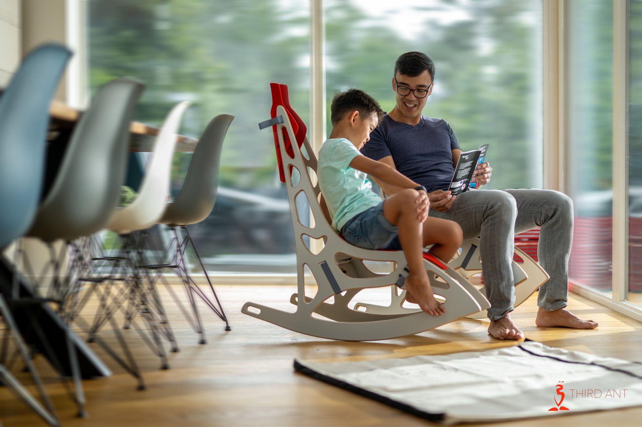 father and son sitting on a gifees and reading